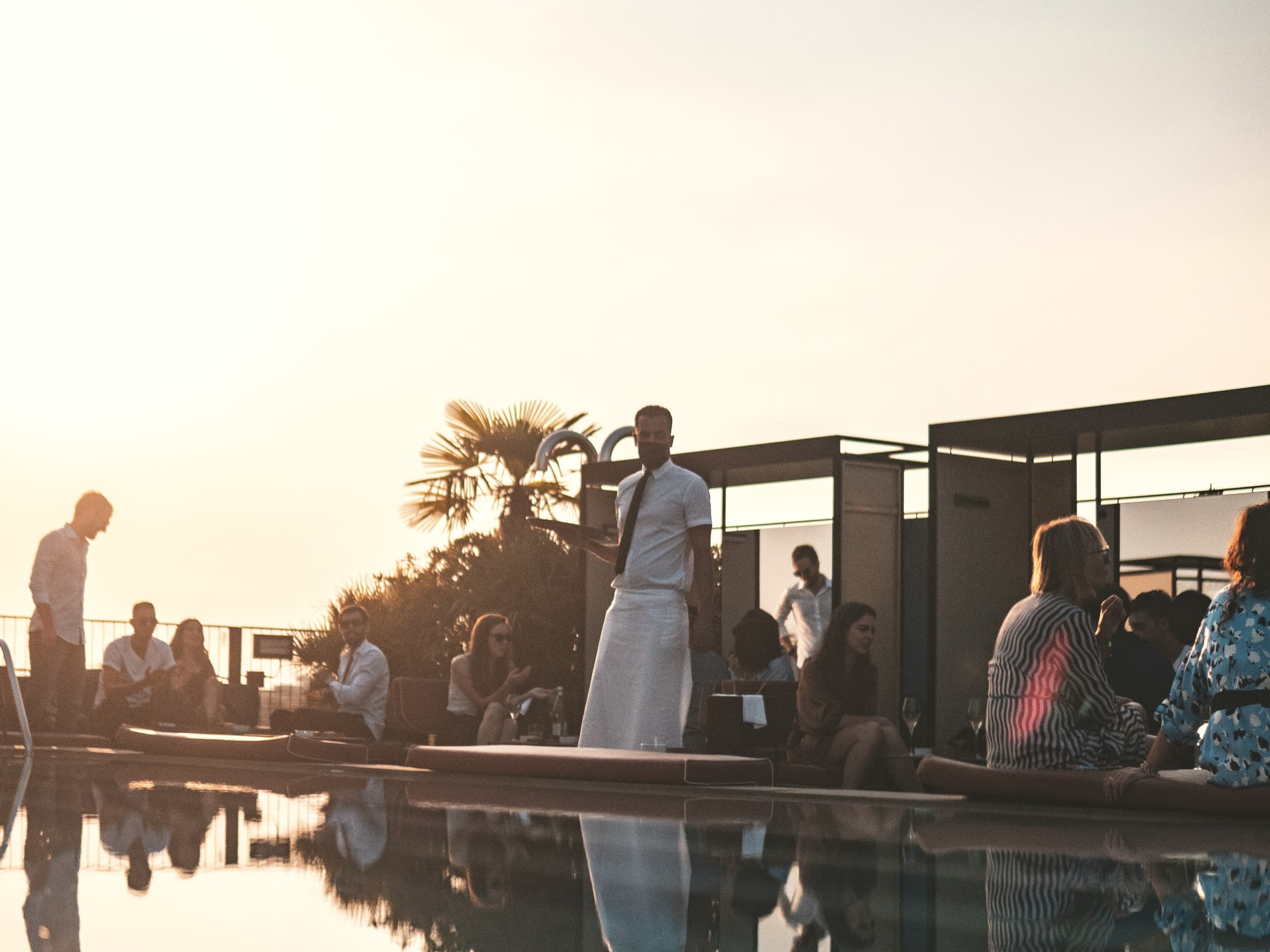 Gäste an einem Pool in der Abendsonne