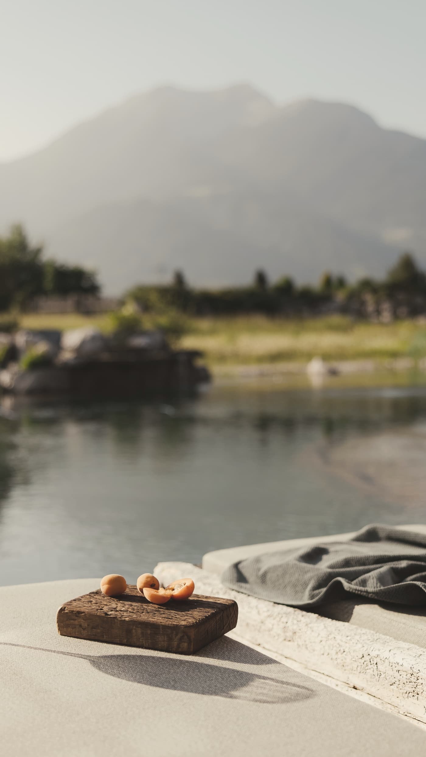 Aperitif auf einer Terrasse über dem See, dahinter die Berge