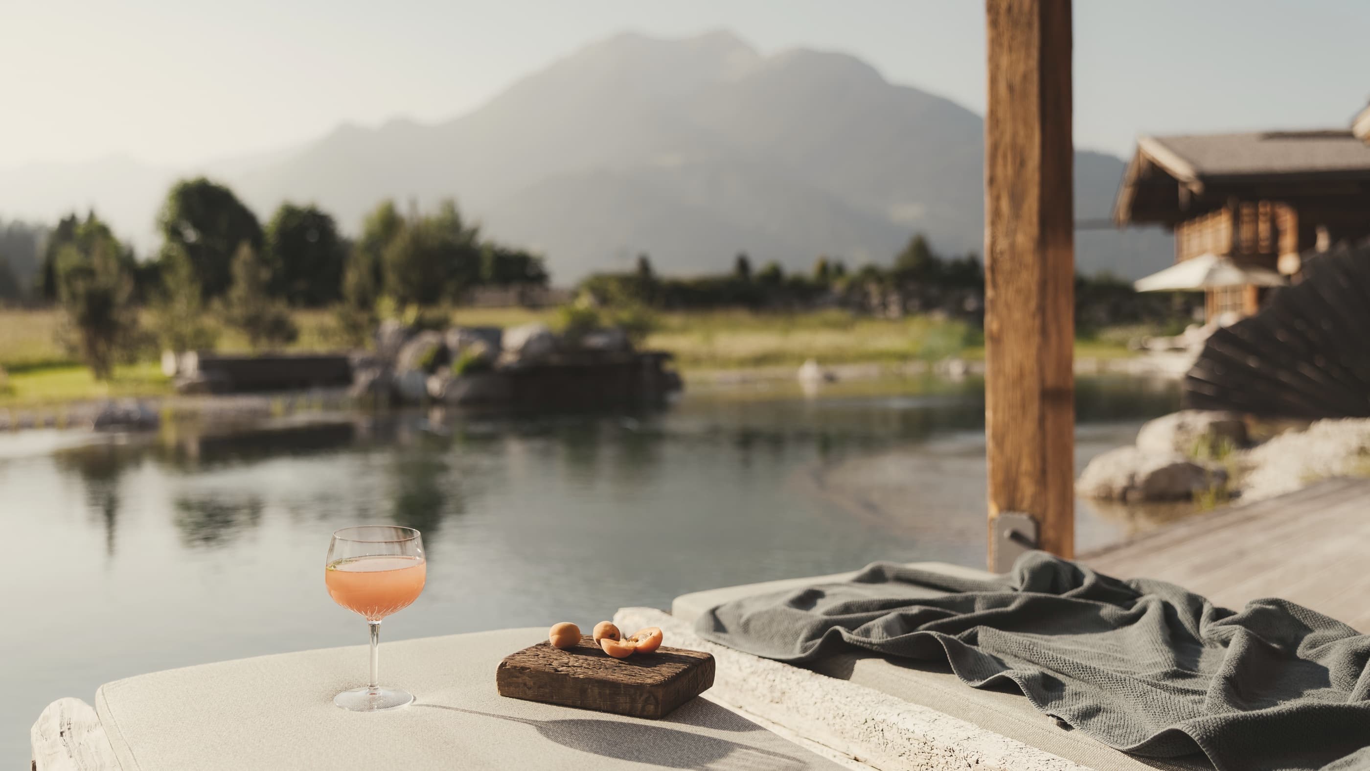 Aperitif auf einer Terrasse über dem See, dahinter die Berge